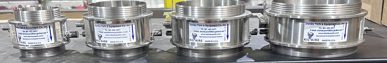 Four stainless steel KilAire air-intake shutdown valves in ascending sizes on a shop bench